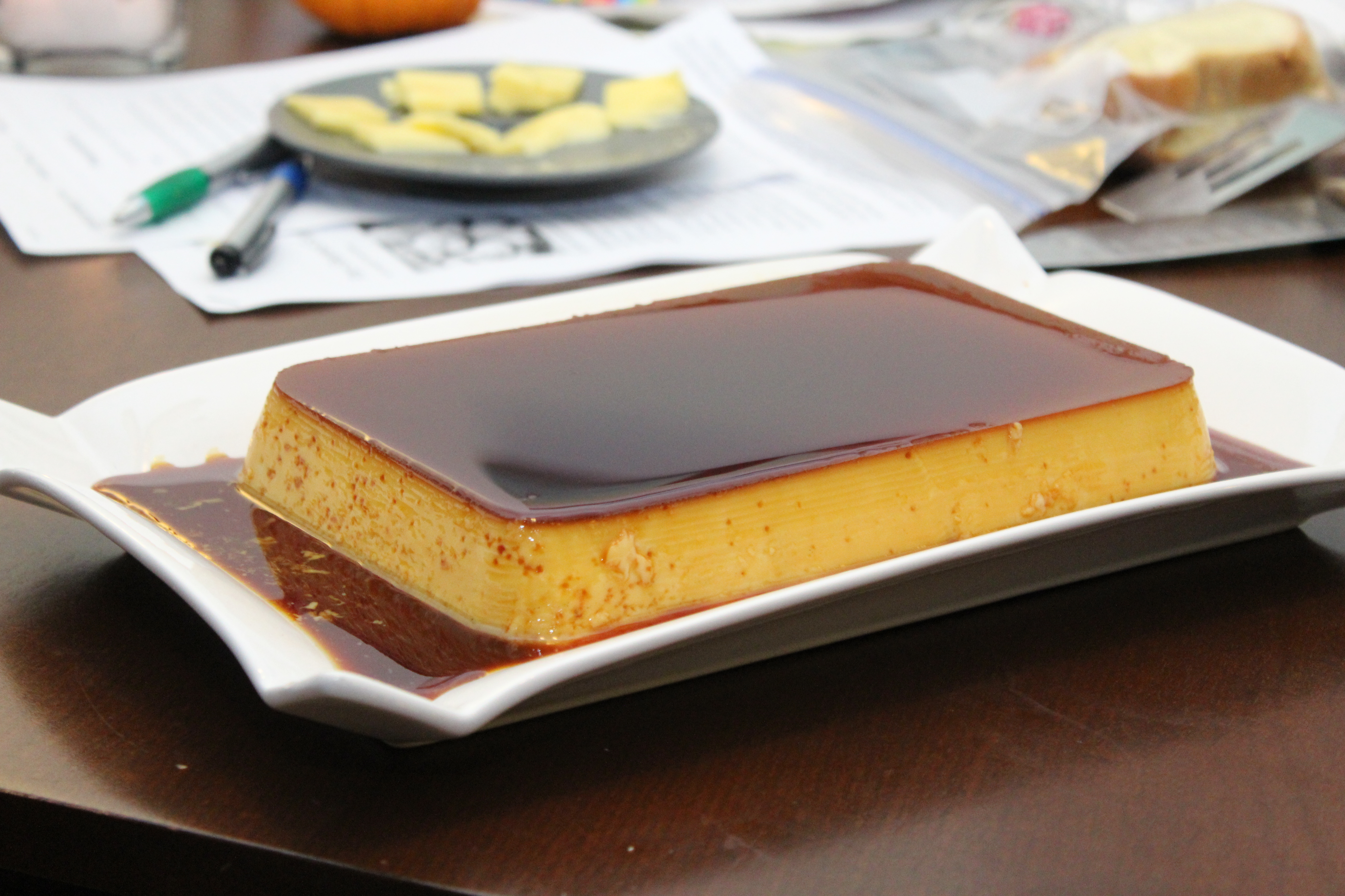 Caramel flan on a white platter with caramel sauce